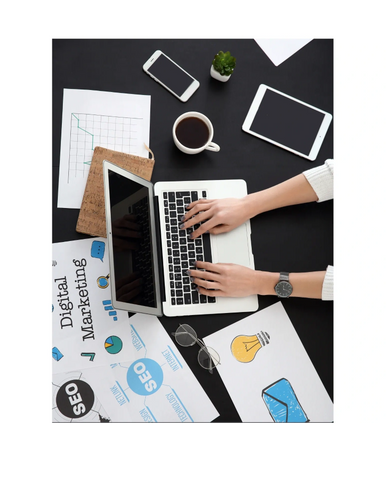 Woman working at computer with papers on the desk.