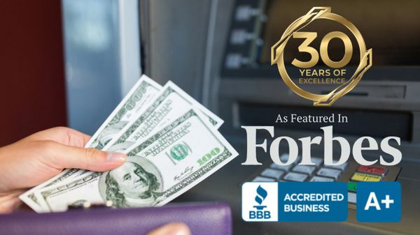 Hand holding cash near ATM with business accreditation and Forbes feature logos.