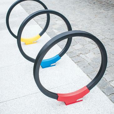Colorful circular bike racks on a sidewalk.