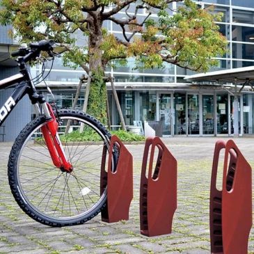 Fahrrad mit ungewöhnlichem Parkständer in Form von Schlössern.
