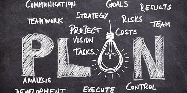 Chalkboard with the word PLAN and related project management terms.