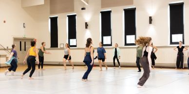 Group dance class practicing in a spacious studio.