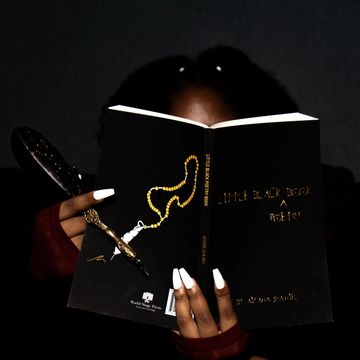 Aiyana Sha'niel reading Little Black Poetry Book with quill.
Photo courtesy of Jae.