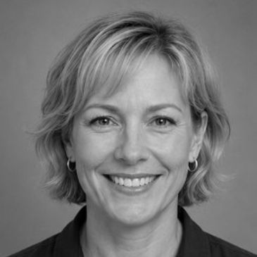 Smiling woman with short blonde hair.