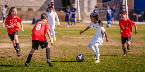 Young soccer players in action during a daytime match on a grassy field.