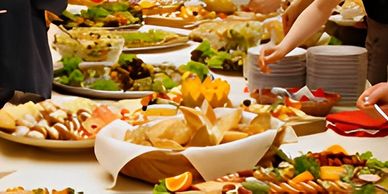 People serving themselves from a diverse buffet spread with many dishes.