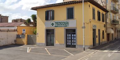 Agenzia immobiliare Tecnocasa in un edificio giallo.
