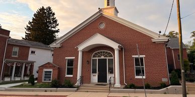 Brick church building with white pillars.