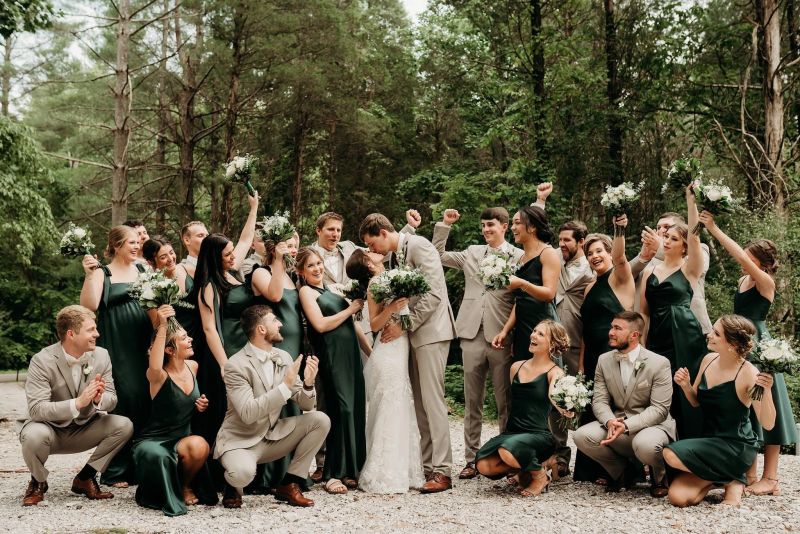 Wedding party cheering as the couple kisses