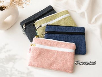 Four colorful fabric zippered pouches arranged on a white cloth.
