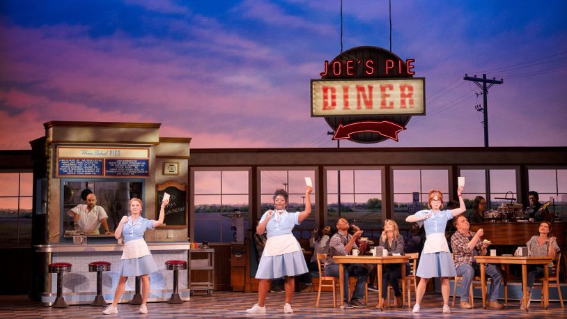 Actors performing in a diner musical scene.