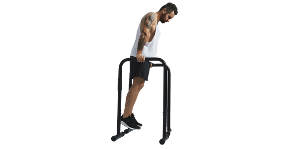 Man performing bodyweight dip exercise on parallel bars at CICO Fitness and Wellness