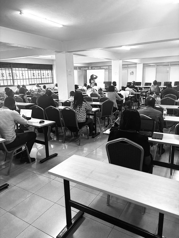 Classroom of adults with laptops attending a lecture.