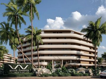 Modern wave-shaped apartment complex surrounded by palm trees under a blue sky.