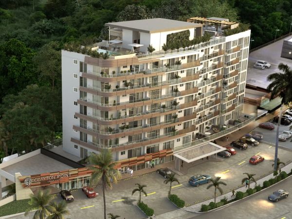 Modern multi-story residential building with balconies and rooftop greenery.