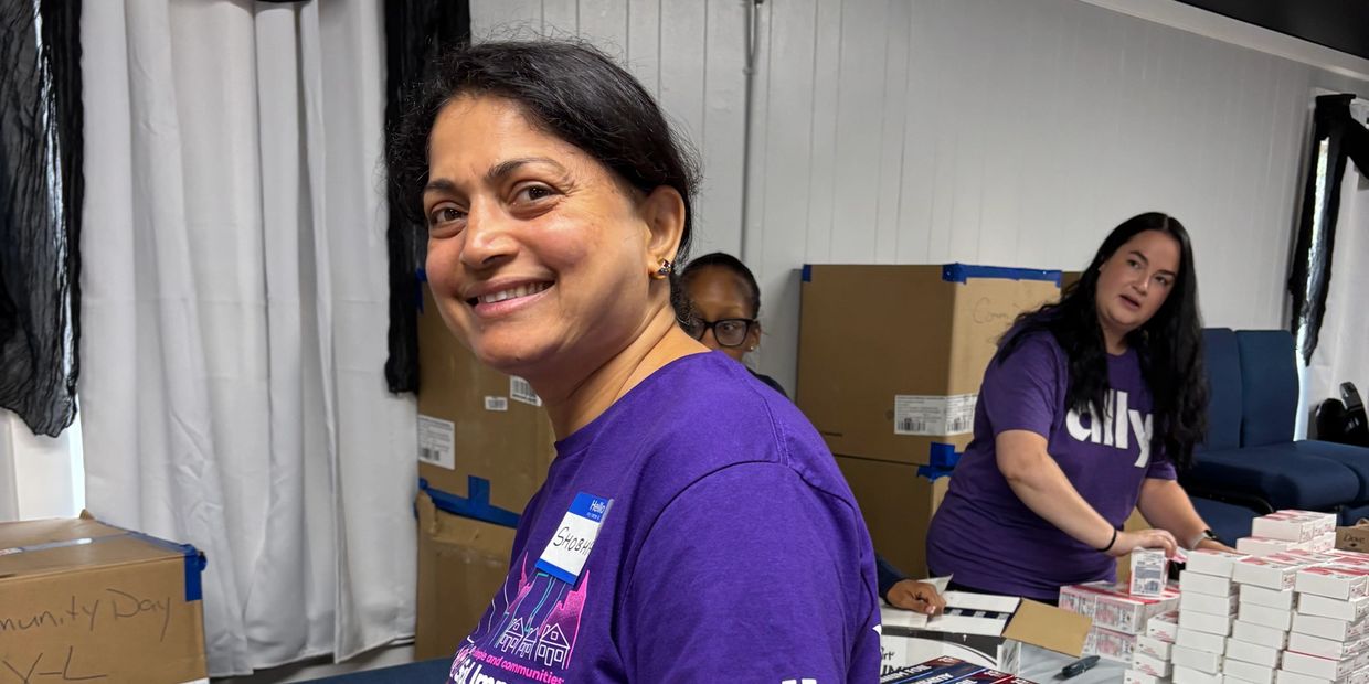 Smiling woman in purple shirt participating in community event with others.
