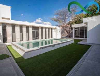 Modern courtyard with a rectangular pool and artificial grass.
