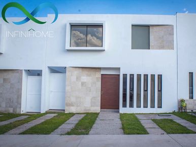 Modern white house exterior with stone accents and green lawn strips.