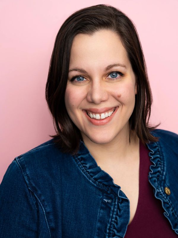 Smiling woman with blue eyes and dark hair.