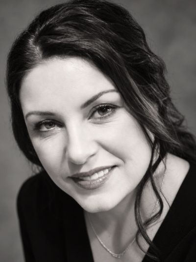Black and white portrait of a smiling woman.