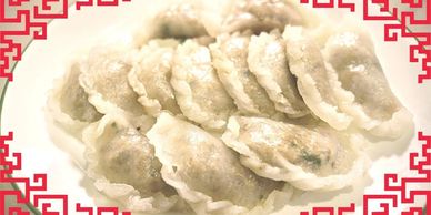 Plate of steamed dumplings with decorative red border.