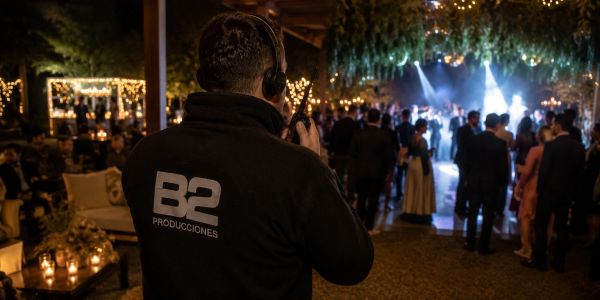Persona con auriculares en evento iluminado con luces cálidas.
