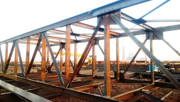 Steel framework of a bridge under construction at a worksite.