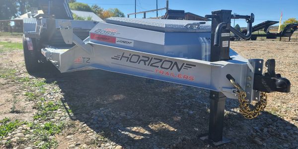 Low bed Horizon Trailers equipment trailer on gravel surface.