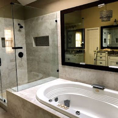 Modern bathroom with glass shower and built-in bathtub.