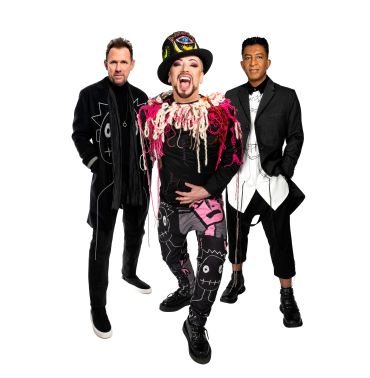 Three men posing in unique outfits against a white background.