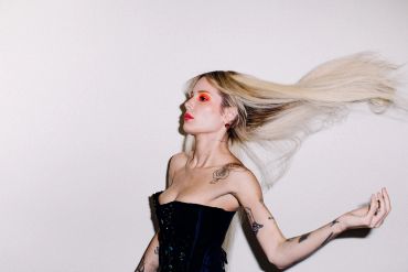 Woman with flying blonde hair and red eye makeup.