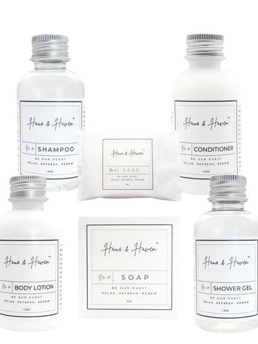 Set of luxury bath products including shampoo, conditioner, body lotion, shower gel, and soap.