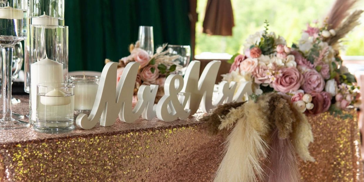 Wedding table decorated with candles, flowers, and Mr & Mrs sign.