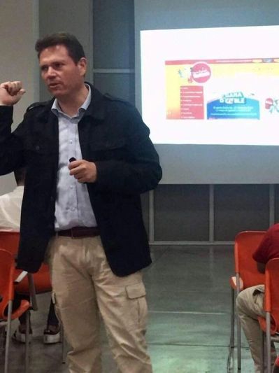 Hombre dando presentación frente a una pantalla.