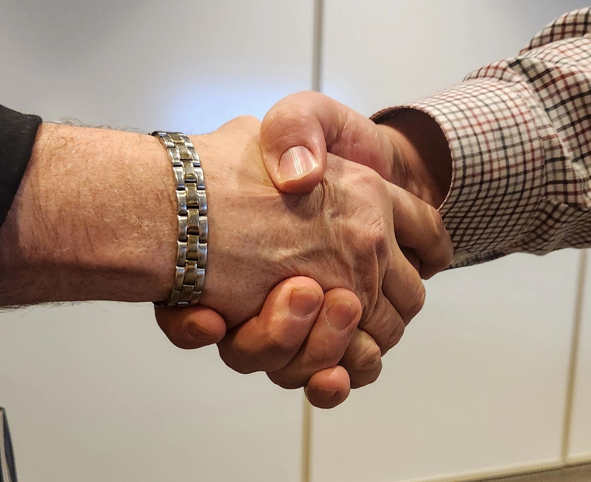 two men shaking hands close up photo