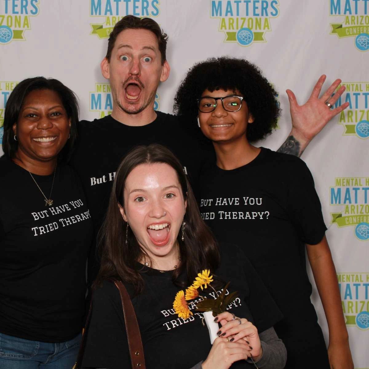 A team has fun while advocating for mental health in a sponsored photo booth at a Phoenix conference