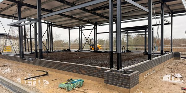Construction site with steel frame and brick foundation.