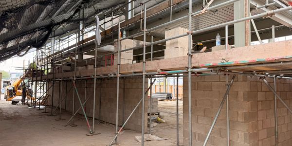 Construction site with scaffolding and brick walls.