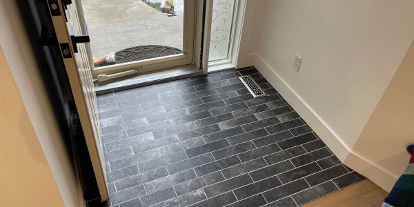 Open door showing tiled floor and doormat outside.