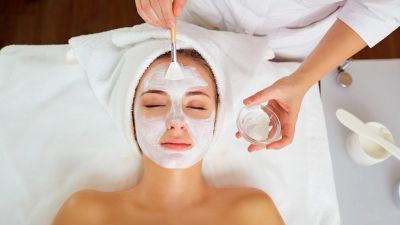 Woman receiving a facial mask treatment.