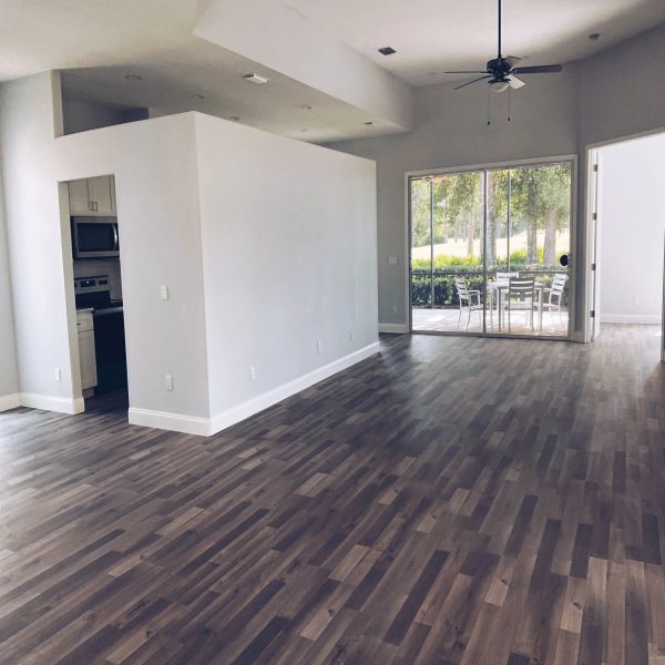 Carpet removal, lvp flooring installation, baseboard removal and replacement, interior wall painting, and installation of a sliding glass door.