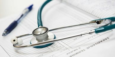 A stethoscope and pen on medical documents.
