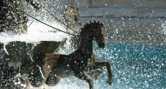 Bronze horse fountain sculpture with splashing water.