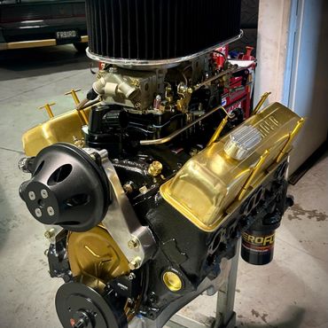 Restored high-performance V8 engine with gold valve covers and polished components.