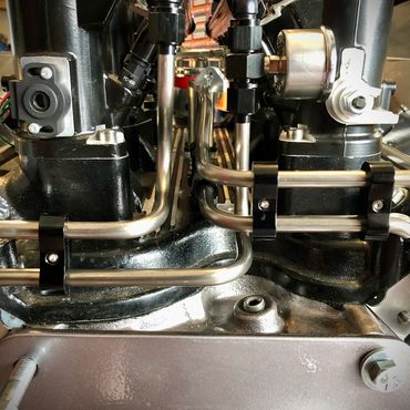Close-up of a polished metal engine part with pipes and connectors.
