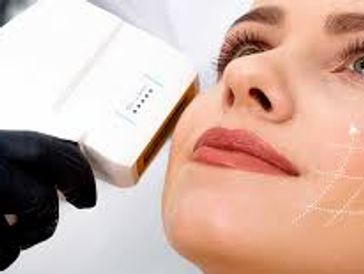 A woman undergoing a facial skin treatment with a handheld device.