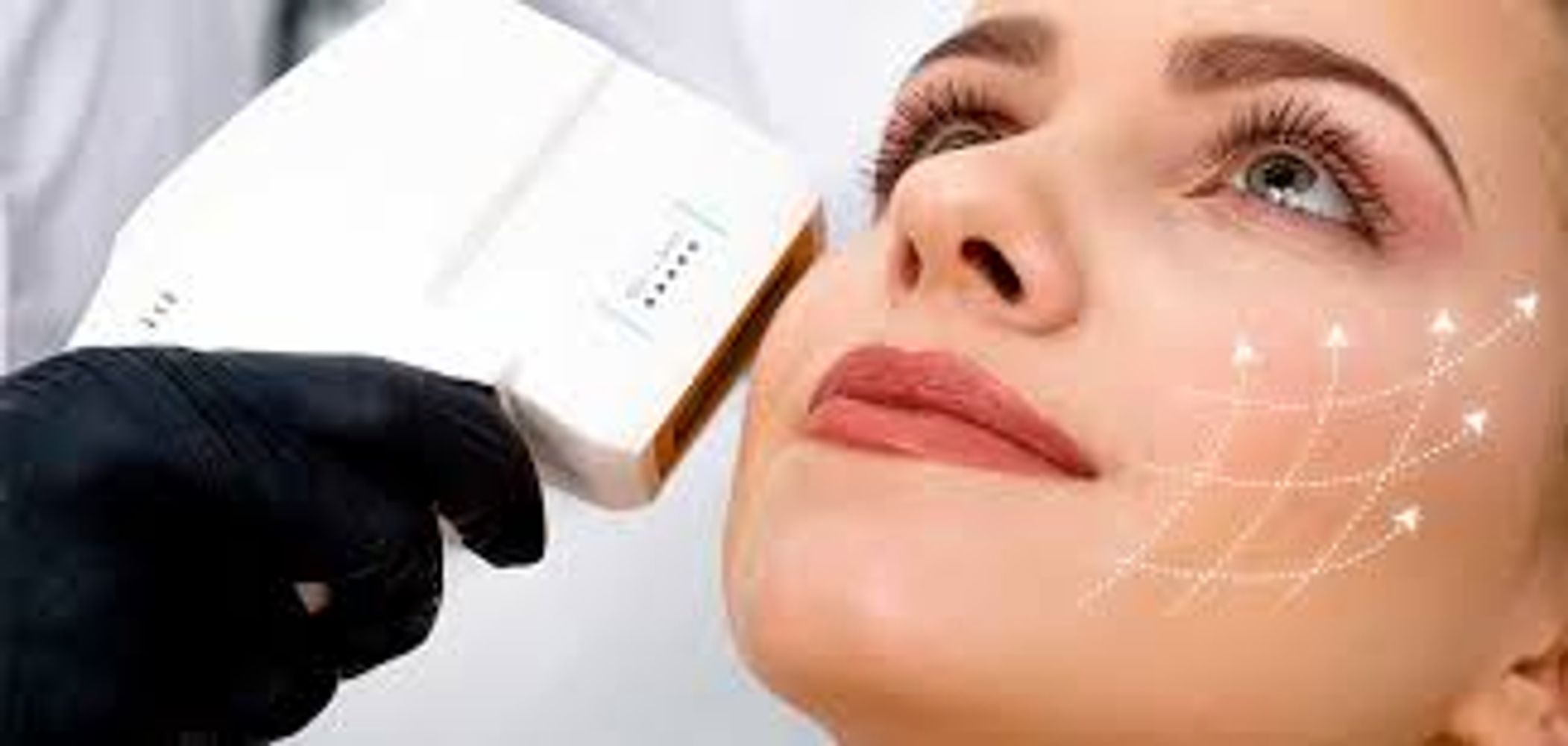 Woman receiving a facial skin treatment with a handheld device.