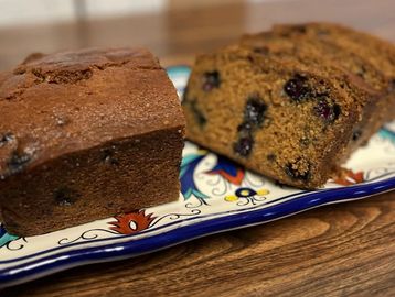 Two slices of blueberry bread on a decorative plate.