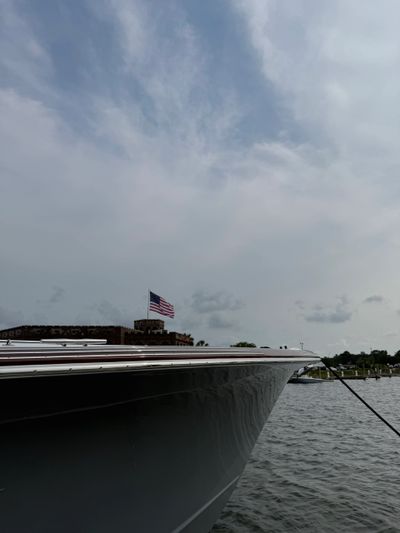 Boat docked near a building with an American flag flying.