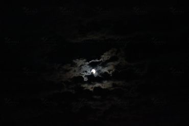 Photo of the moon behind clouds in Colorado